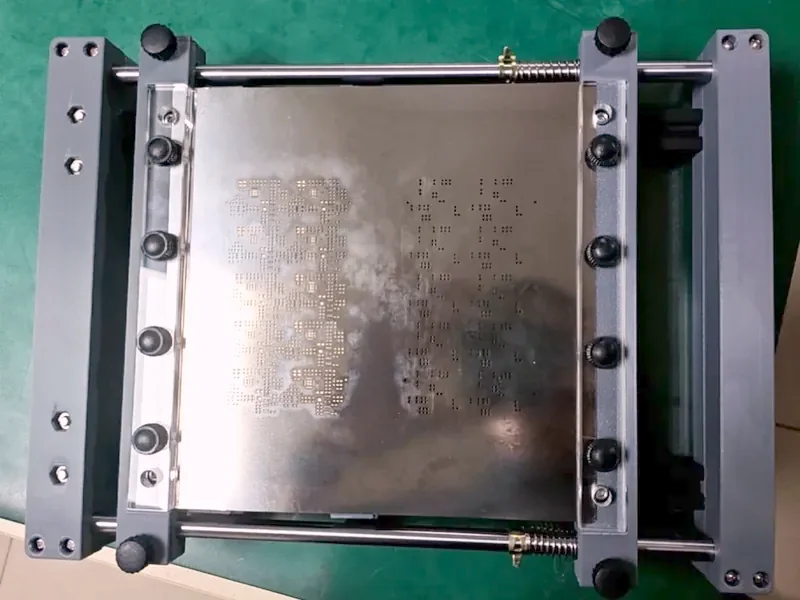 Stainless stencil foil clamped in a mesh tensioning jig