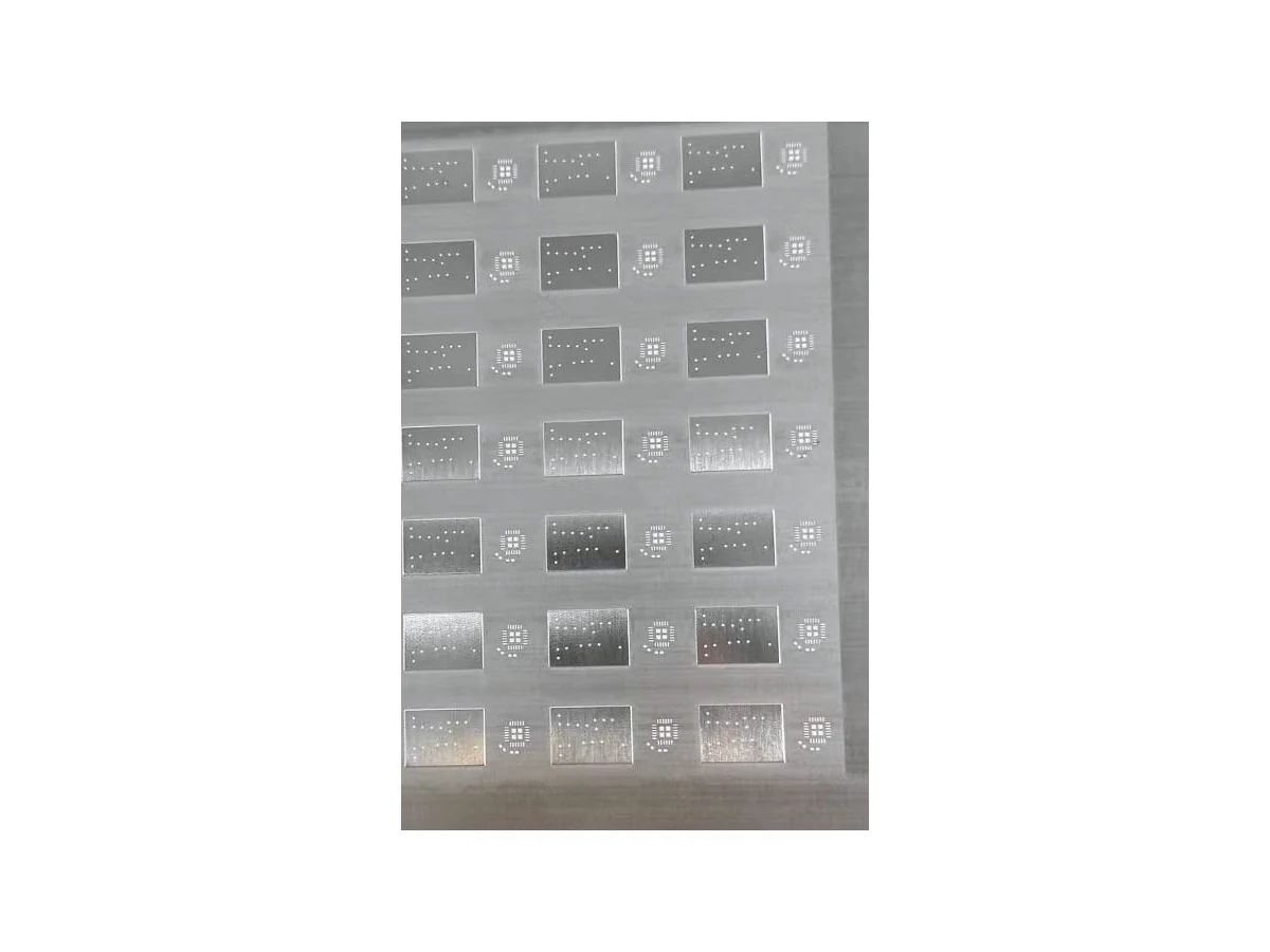 Step stencil photographed on the bench: laser-cut apertures in a stainless steel foil